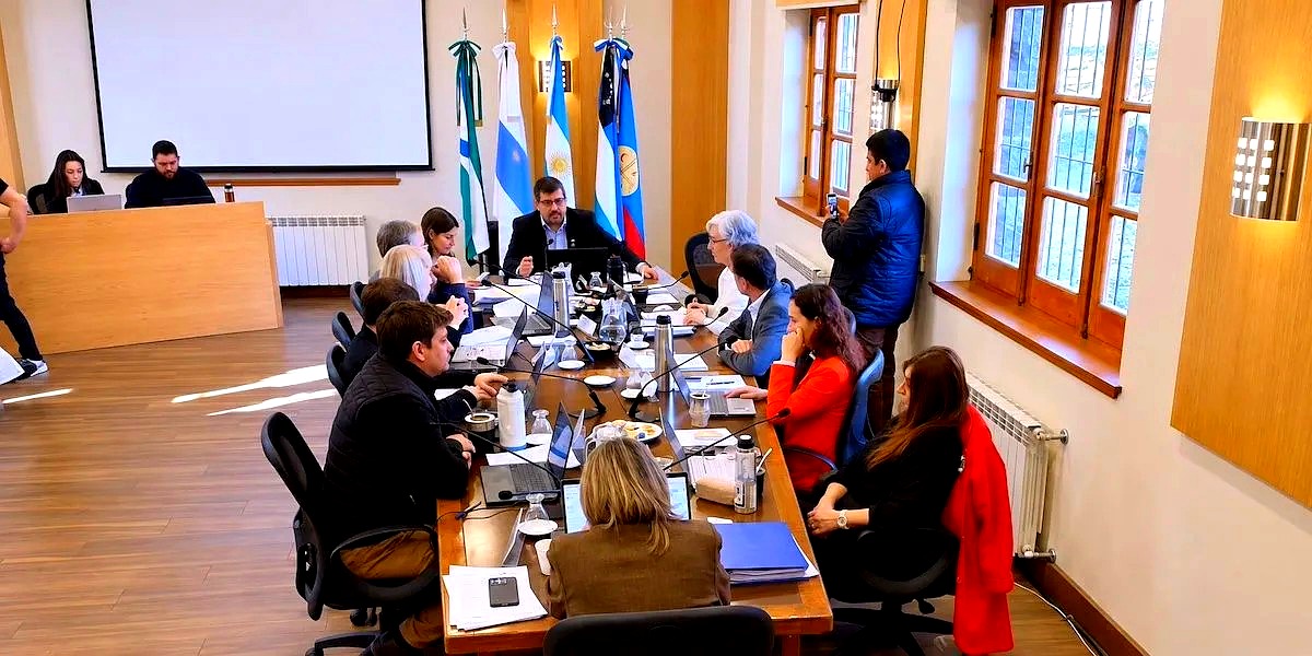 Concejo Deliberante de Bariloche en sesión, con banderas de fondo