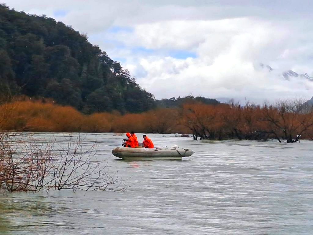 Cascada Los Alerces y El Manso: brigadistas del Parque Nacional en bote sobre el río Manso crecido