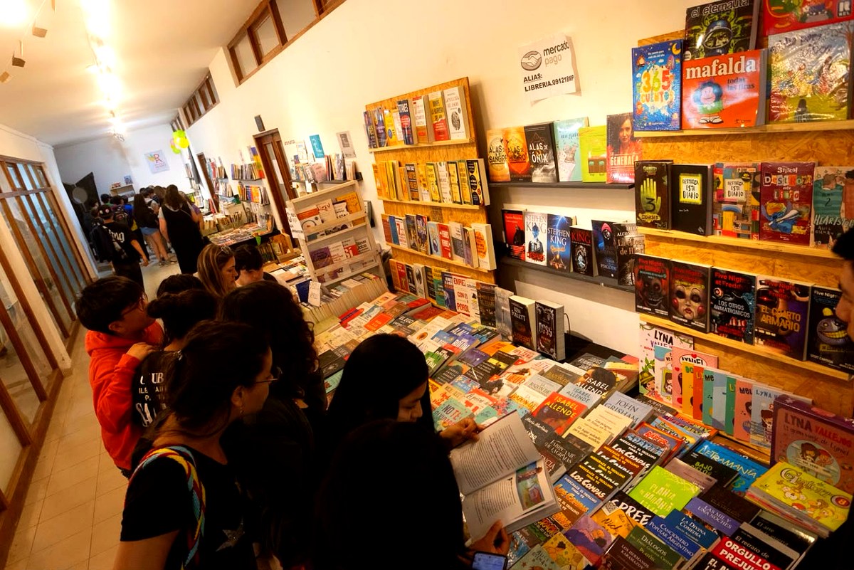 Lectores recorren mesas de libros, imagen ilustrativa de la Feria del Libro de Viedma