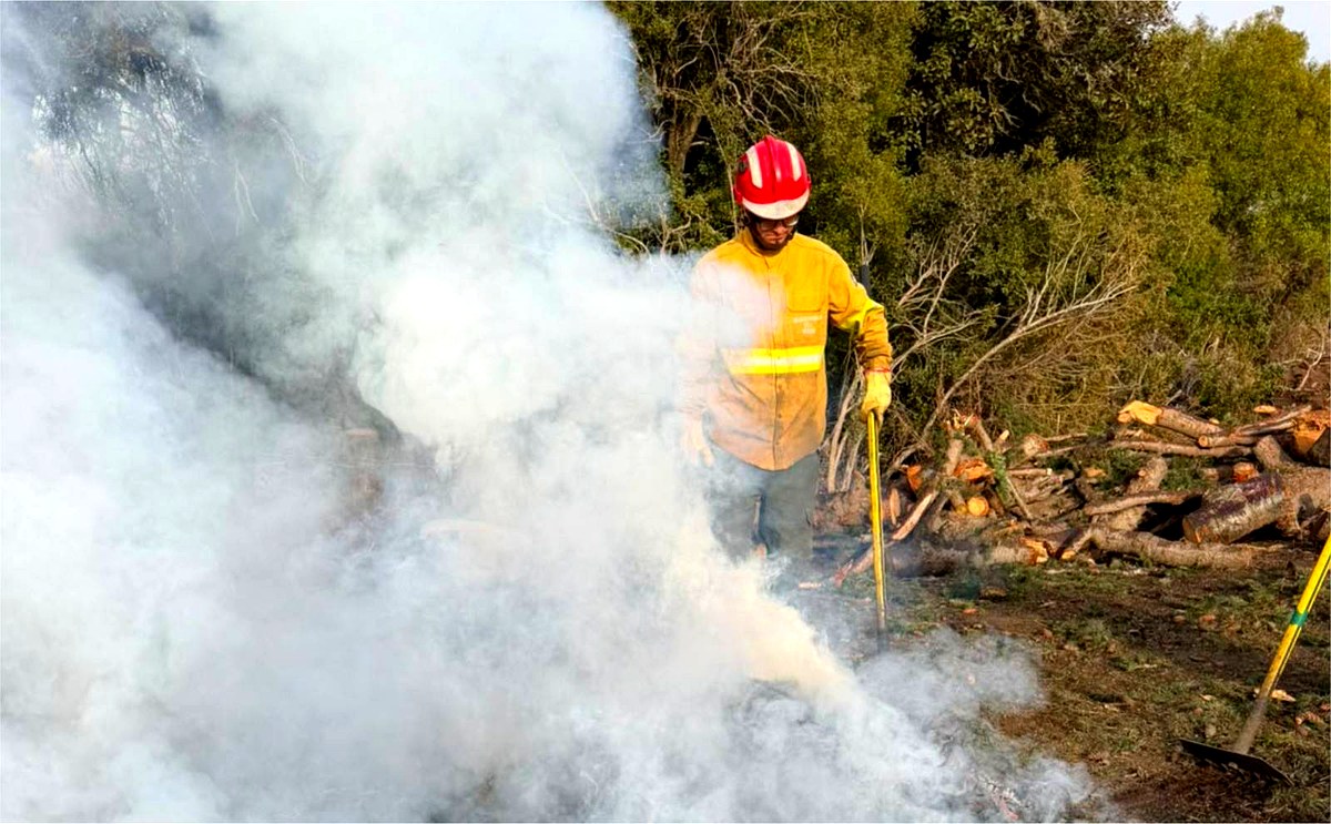Brigadista controla una quema de residuos de poda en la Comarca Andina